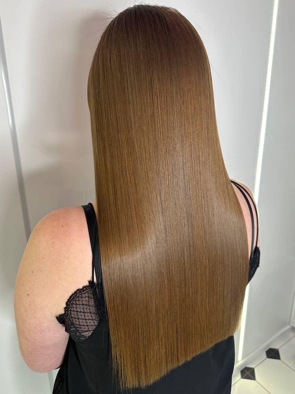 Résultat lisse et miroir sur cheveux châtain clair.